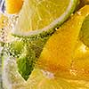In a clear glass mint leaf, slices of lime and lemon with bubbles. Macro photo of summer cooling mojito
