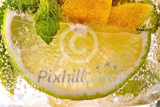 Cold mojito with green mint leaves slices of lime, lemon and bubbles in a glass. Refreshing summer drink Cold mojito with green mint leaves slices of lime, lemon and bubbles in a glass. Refreshing summer drink