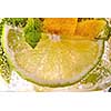 Cold mojito with green mint leaves slices of lime, lemon and bubbles in a glass. Refreshing summer drink