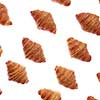 Food pattern with freshly baked homemade delicious croissants on a white background.