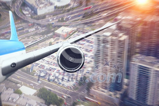 Wing of airplane taking off above modern cityscape . Mixed media Wing of airplane taking off above modern cityscape . Mixed media