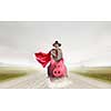 Young businesswoman in red cape riding on piggy bank. Mixed media