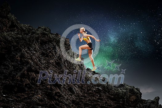 Slim attractive sportswoman running up the hill. Mixed media