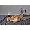 Morning breakfast with french homemade crunchy homemade croissants on a plate with freshly brewed fragrant coffee on a dark textile background. Copy space.