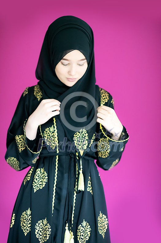beautiful muslim woman in fashinable dress with hijab isolated on modern plastic pink background representing modern islam fashion and ramadan kareem concept