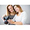 Mother and daughter taking photos and checking them on a modern digital DSLR camera