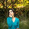 Cute young woman picking apples in an orchard having fun harvesting the ripe fruits of her family's labour(color toned image)