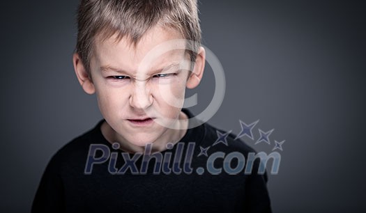 Loads of aggression in a little boy - education concept hinting behavioral problems in young children (shallow DOF) - little boy with hands clenched into fists about to punch someone