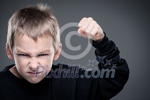 Loads of aggression in a little boy - education concept hinting behavioral problems in young children (shallow DOF) - little boy with hands clenched into fists about to punch someone Loads of aggression in a little boy - education concept hinting behavioral problems in young children (shallow DOF) - little boy with hands clenched into fists about to punch someone