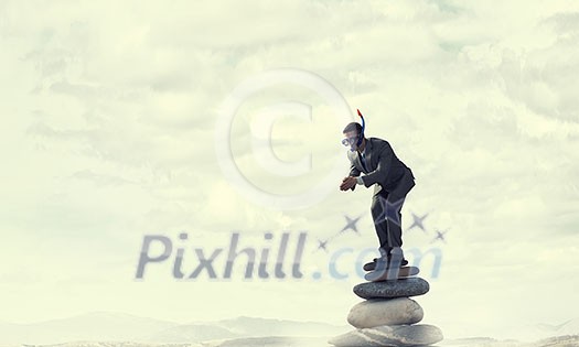 Man wearing suit and diving mask jumping from rock top. Mixed media . Mixed media Man wearing suit and diving mask jumping from rock top. Mixed media . Mixed media