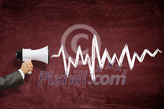 Hand of person holding megaphone against chalkboard background