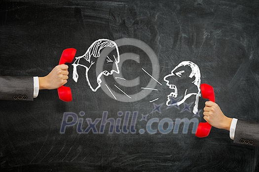 Hand holding vintage telephone receiver over chalkboard background Hand holding vintage telephone receiver over chalkboard background