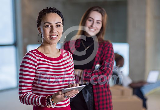 young multiethnic team of business people in group, architect and engineer on construction site checking documents and business workflow using laptop and tablet computer in new startup office