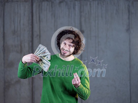 business, people and finances concept  happy young business man displaying a spread of american dollar cash money in new startup office