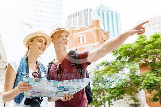 Happy young couple as tourists with a map