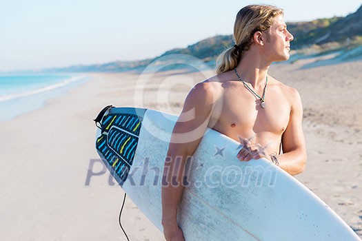 A young surfer with his board on the beach A young surfer with his board on the beach