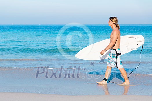 A young surfer with his board on the beach A young surfer with his board on the beach
