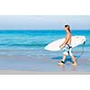 A young surfer with his board on the beach