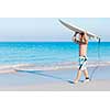 A young surfer with his board on the beach