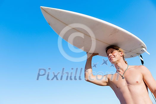 A young surfer with his board on the beach