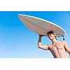 A young surfer with his board on the beach