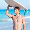 A young surfer with his board on the beach