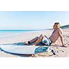 A young surfer with his board on the beach