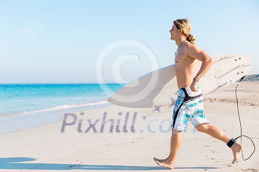 A young surfer with his board on the beach A young surfer with his board on the beach