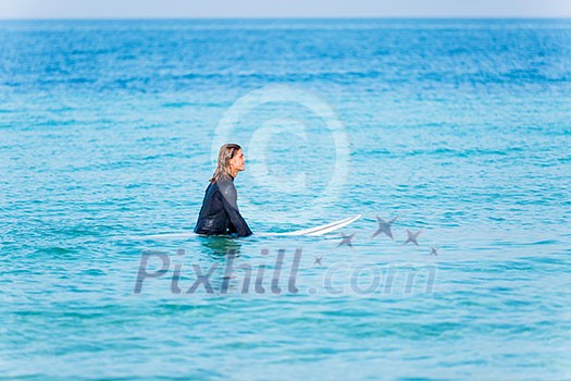 A young surfer with his board on the beach