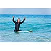 A young surfer with his board on the beach