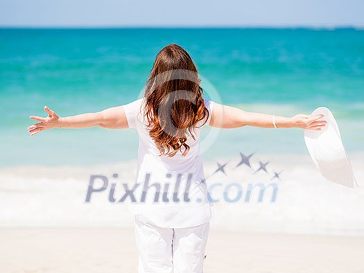 Woman in white clothes on the beach on sunny day