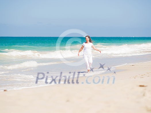 Woman in white clothes on the beach on sunny day