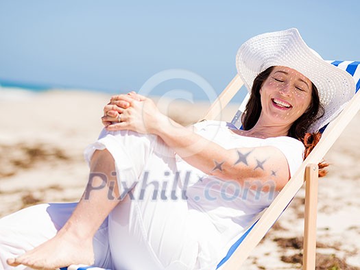 Woman in white clothes on the beach on sunny day