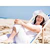 Woman in white clothes on the beach on sunny day