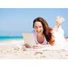 Woman in white clothes on the beach with tablet