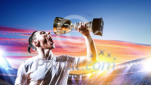 Athlete drinking from cup trophy against stadium. Mixed media Athlete drinking from cup trophy against stadium. Mixed media