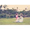 Young Mother and cute little daughter enjoying free time playing outside at backyard on the grass, happy family in nature concept