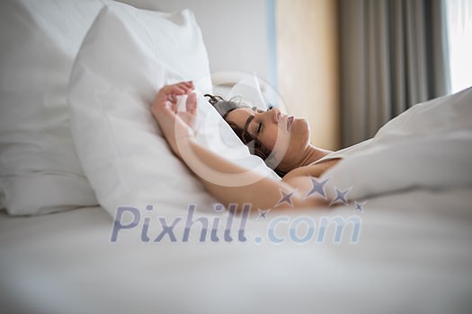 Beautiful young woman sleeping on bed at bedroom