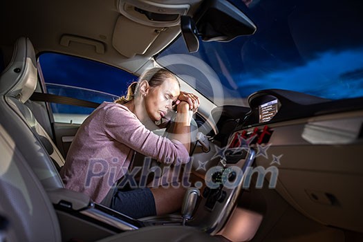 Young female driver at the wheel of her car, super tired, falling asleep while driving in a potentially dangerous situation - Road safety concept