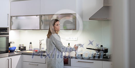 Pretty, young woman in her modern bright kitchen - healthy eating concept, household lifestyle concept Pretty, young woman in her modern bright kitchen - healthy eating concept, household lifestyle concept