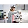 Pretty, young woman in her modern bright kitchen - healthy eating concept, household lifestyle concept