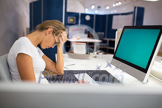 Overworked/burnout office employe at her computer, suffering from a headache, meeting deadlines, working hard despite being exhausted. Exhausted businesswoman having a headache at office. (shallow DOF; color toned image) Overworked/burnout office employe at her computer, suffering from a headache, meeting deadlines, working hard despite being exhausted. Exhausted businesswoman having a headache at office. (shallow DOF; color toned image)
