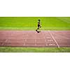 Runner on a running track finishing a race first (motion blurred image)