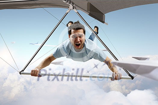 Brave hang glider pilot soaring high in sky. Mixed media Brave hang glider pilot soaring high in sky. Mixed media