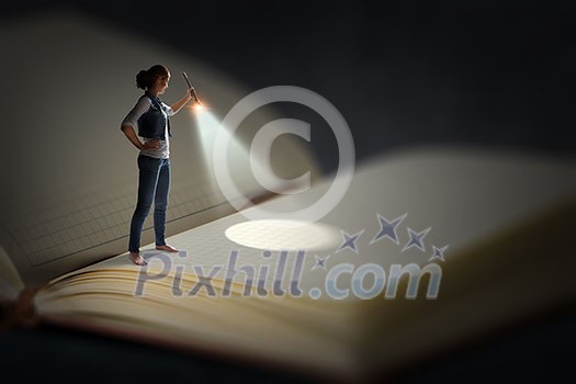 Woman with flashlight standing on pages of huge book. Mixed media