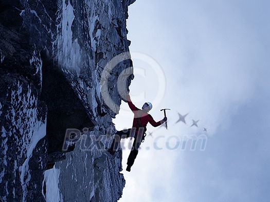 Young man climber hanging on slope cliff. Mixed mefia