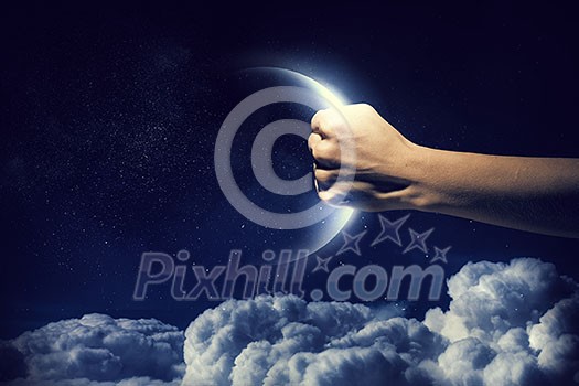 Human hand catching moon planet in palm