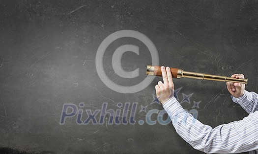 Close of man holding in hands spyglass Close of man holding in hands spyglass