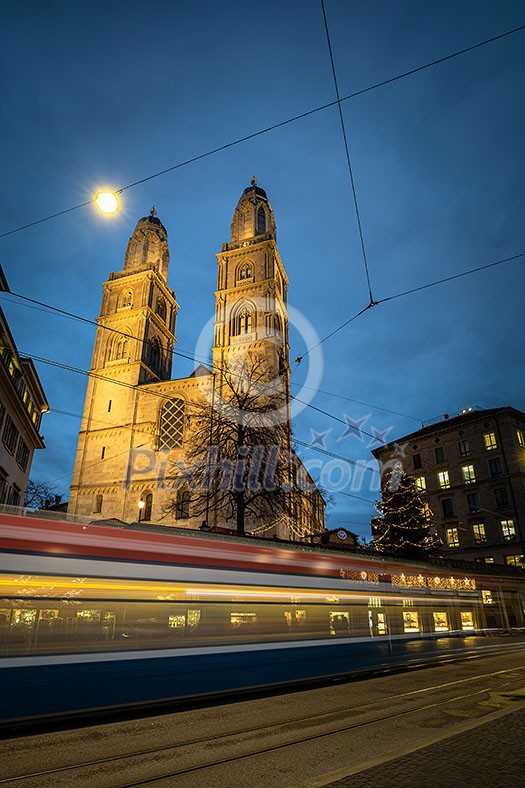 Zurich, Switzerland - view of the Grossmünster church with motion blurred tramway during Chrostmas time Zurich, Switzerland - view of the Grossmünster church with motion blurred tramway during Chrostmas time