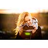 Cute female photographer with her dslr camera taking photos outdoor at sunset - photography taking concept (color toned image)